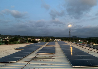 Rooftop solar panels with a darkening sky in the background. 