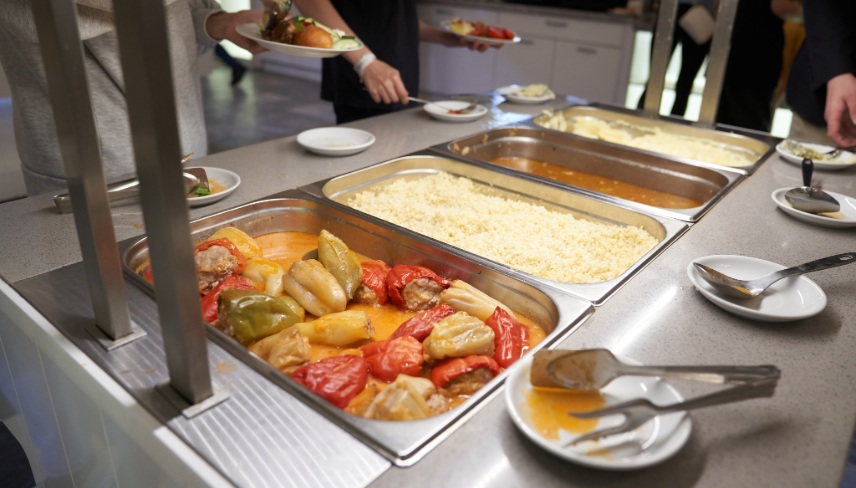 A buffet with Russian dishes, which features traditional dishes in metal containers. 