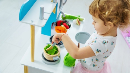 the child plays in the kitchen and cooks